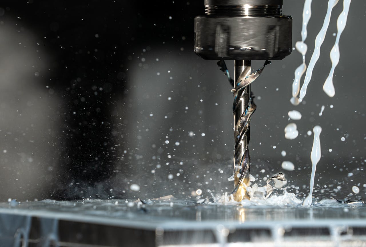 Crafting Captivating Headlines: Your awesome post title goes here High-speed close-up of CNC drill bit in action with water splash for lubrication.